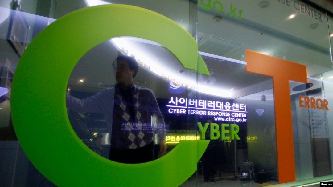 FILE - An investigator entering the Cyber Terror Response Center of the Korean National Police Agency is reflected on a window in Seoul.