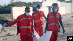 Sejumlah petugas medis membawa jenazah salah satu korban pengeboman bunuh diri yang menarget konvoi di Mogadishu, Somalia, 11 November 2021. 