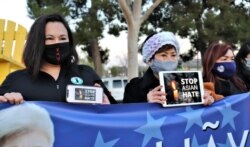 17일 미국 캘리포니아주 가든그로브에서 열린 '아시아계 주민에 대한 혐오를 멈춰라(Stop Asian Hate)' 집회에서 태미 김(왼쪽) 어바인 부시장 등 참가자들이 표어를 들어보이고 있다.