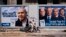 FILE - People walk by election campaign billboards showing Israeli Prime Minister Benjamin Netanyahu, left, alongside the Blue and White party leaders, from left to right, Moshe Yaalon, Benny Gantz, Yair Lapid and Gabi Ashkenazi, in Tel Aviv, Israel, April 3, 2019.