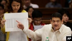 FILE - Philippine Sen. Teofisto Guingona III gestures as he shows a document during hearings into how about $81 million of Bangladesh's stolen funds were transmitted online to four private accounts at a branch of the Rizal Commercial Banking Corp. during 