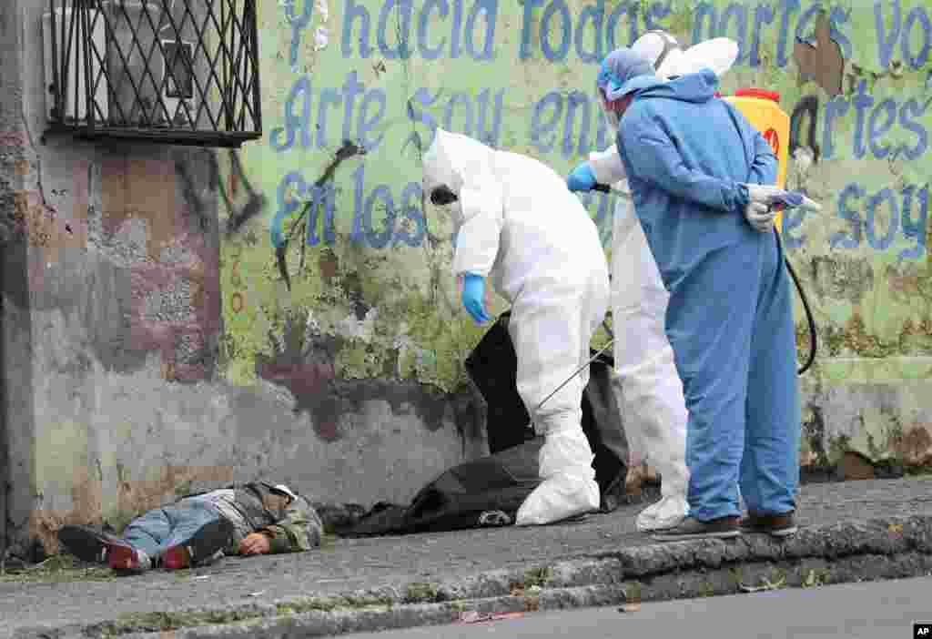 Forensic investigators look at the body of a man infected with the coronavirus who collapsed on the street and died, according to Police Captain Diego Lopez, in Quito, Ecuador, May 5, 2020.