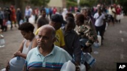 In this Feb. 2, 2018 photo, residents wait to fill containers with water at a source for natural spring water in Cape Town. South Africa's drought-hit city of Cape Town said on its web site that Day Zero had been “pushed out to 2019.” Stringent consumption restrictions, which now stand at 50 liters per person per day, will remain in effect.