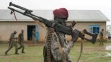 FILE - A presidential protection guard from South Sudan's People Defense Force (SSPDF) walks in the rain after a parade at the training site in Rejaf West, outside Juba, South Sudan, April 26, 2019.