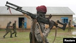 FILE - A presidential protection guard from South Sudan's People Defense Force (SSPDF) walks in the rain after a parade at the training site in Rejaf West, outside Juba, South Sudan, April 26, 2019.