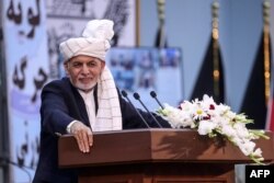FILE - Afghan President Ashraf Ghani speaks at the Loya Jirga Hall in Kabul, in this handout photograph taken Aug. 7, 2020, and released by his office.