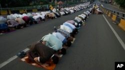 Gran cantidad de musulmanes efectúan las oraciones de la celebración del Eid al-Adha el lunes 17 de junio de 2024, en una calle de Yakarta, Indonesia. 