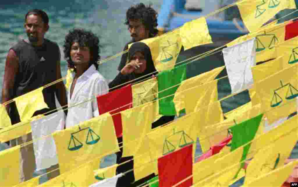 Boats decorated with flags carrying supporters of former President Mohamed Nasheed's Maldivian Democratic Party arrive in Male, Maldives, Friday, Feb. 17, 2012. Supporters of Nasheed started to gather from village islands to capital Male to continue to ho