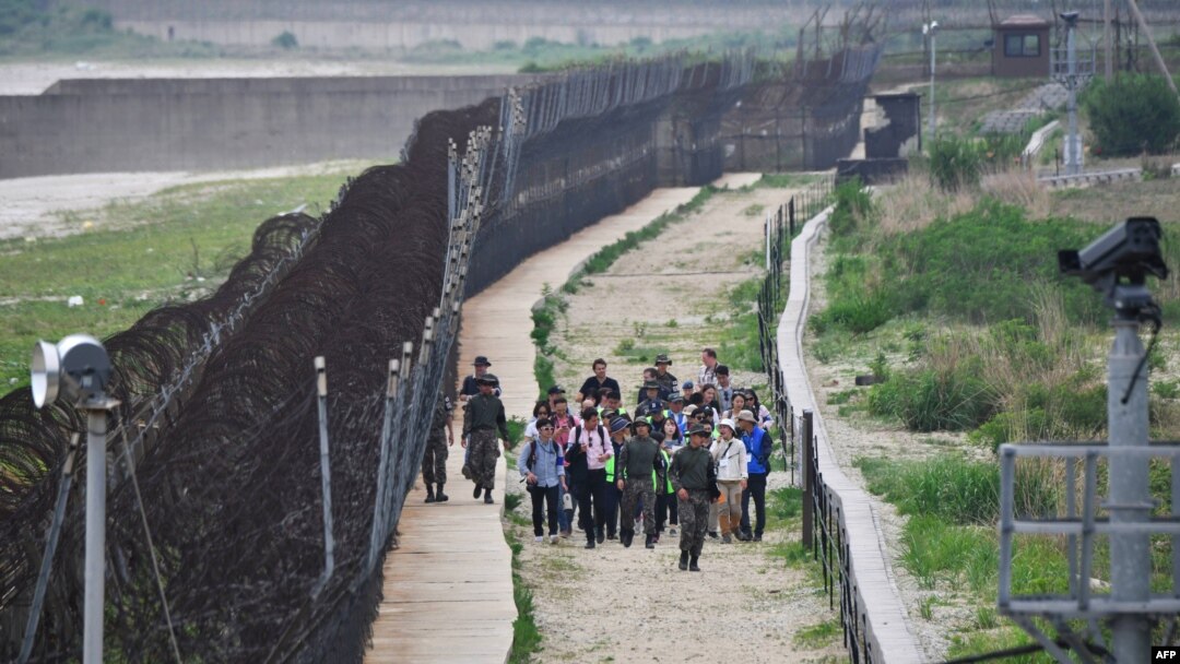 Para tentara Korea Selatan mengawal para pengunjung berjalan menyusuri zona demiliterisasi (DMZ) antara dua Korea yang dipisahkan pagar, Goseong, 14 Juni 2019. 
