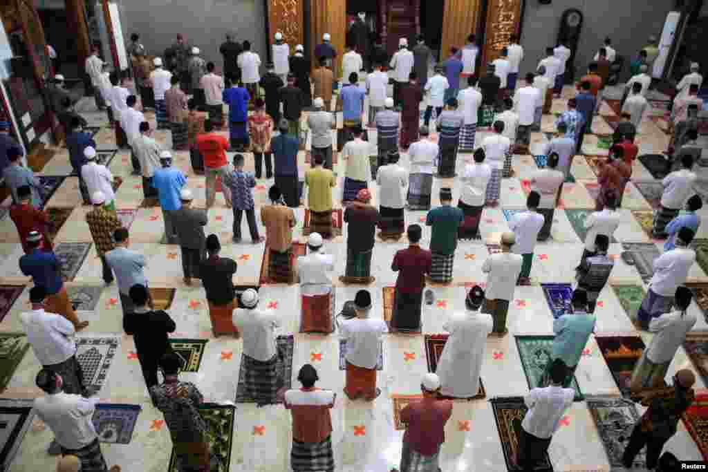 Muslim melakukan salat Idul Fitri dengan menjaga jarak aman di sebuah masjid di Sidoarjo, Jawa Timur.&nbsp;