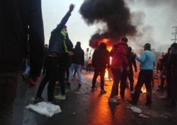 FILE - Iranian protesters gather around a fire during a demonstration against an increase in gasoline prices in the capital Tehran, Nov. 16, 2019.