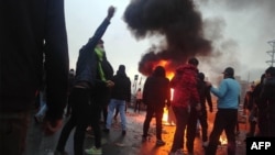 FILE - Iranian protesters gather around a fire during a demonstration against an increase in gasoline prices in the capital Tehran, Nov. 16, 2019.