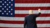 FILE - President Donald Trump waves in front of an American flag as he leaves after speaking during a rally at the Kentucky Exposition Center, March 20, 2017, in Louisville, Kentucky.