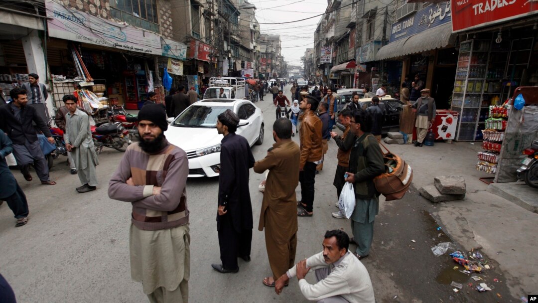 Warga Rawalpindi, Pakistan berdiri di luar toko mereka setelah merasakan gempa bumi yang mengguncang hebat kawasan tersebut, 31 Januari 2018.