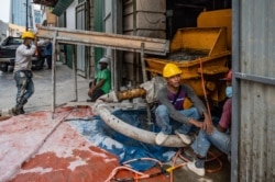 FILE - Workers rest at a construction site in Kuala Lumpur on July 3, 2020.