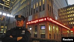 Un policía de Nueva York monta guardia frente a una pantalla que menciona el arresto de un sospechoso de Bangladesh que pensaba atentar en la ciudad, contra la Reserva Federal.