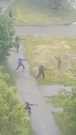 Unidentified men shoot during an armed conflict in the residential area of Brovary town, Ukraine, in this still image from a video taken May 29, 2020. (Oleksandr Tkachenko/Handout via Reuters)