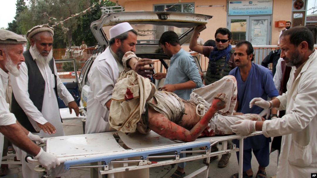 FILE - A wounded man is brought by stretcher into a hospital after an explosion at a mosque in Haskamena district of Jalalabad, east of Kabul, Afghanistan, Oct. 18, 2019. 