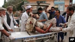 FILE - A wounded man is brought by stretcher into a hospital after an explosion at a mosque in Haskamena district of Jalalabad, east of Kabul, Afghanistan, Oct. 18, 2019. 