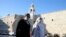 Christians walk towards the Church of the Nativity that reopened Tuesday to visitors after a nearly three-month closure due to the coronavirus pandemic, in Bethlehem, West Bank, May 26, 2020. 