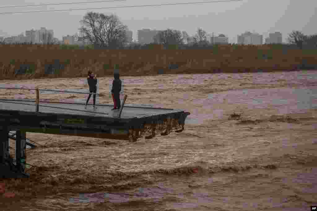Two people take snapshots atop of a collapsed bridge in Malgrat, near Barcelona, Spain.