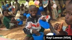 Des élèves savourant leur déjeuner à l'école primaire publique de Louanga, Togo, 23 mai 2017. (VOA/Kayi Lawson).