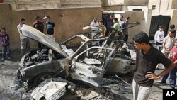 People inspect a car destroyed after a bomb attached to it exploded in Basra, Iraq's second-largest city, 550 kilometers southeast of Baghdad, Iraq, 28 Oct 2010