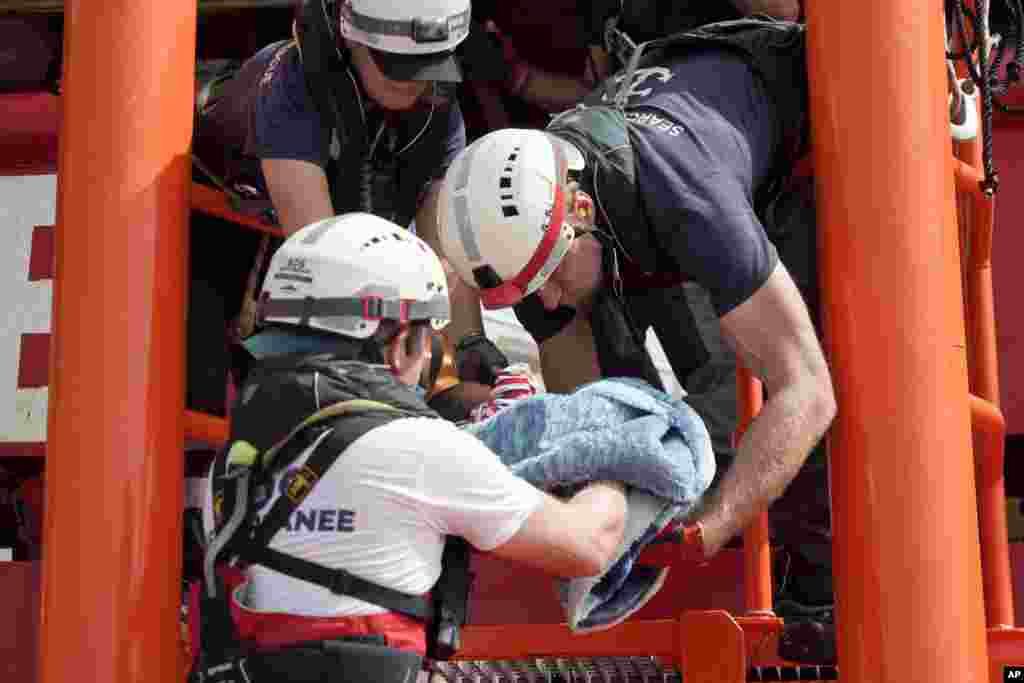 A newborn baby is carried onto the Ocean Viking humanitarian rescue ship after a rescue operation some 53 nautical miles (98 kilometers) from the coast of Libya in the Mediterranean Sea.