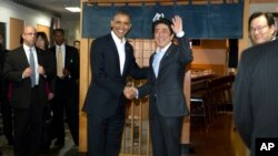 President Barack Obama and Japanese Prime Minister Shinzo Abe shake hands before having dinner at Sukiyabashi Jiro sushi restaurant in Tokyo, April 23, 2014. 