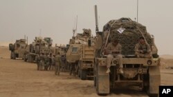 In this Nov. 7, 2017, photo, U.S. Marines prepares to build a military site in western Anbar, Iraq. The US-led coalition's outpost in the fight against the Islamic State group is in a corner of western Iraq near the border with Syria.