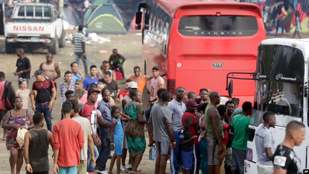 En esta imagen del 10 de mayo de 2019, un grupo de migrantes esperan para subir a un autobús que los lleve en su viaje al norte, en Peñitas, en la provincia de Darién, Panamá. (AP Foto/Arnulfo Franco)