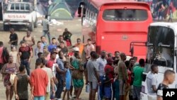 En esta imagen del 10 de mayo de 2019, un grupo de migrantes esperan para subir a un autobús que los lleve en su viaje al norte, en Peñitas, en la provincia de Darién, Panamá. (AP Foto/Arnulfo Franco)