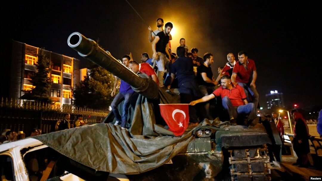 People stand on a Turkish army tank in Ankara, Turkey, July 16, 2016. 