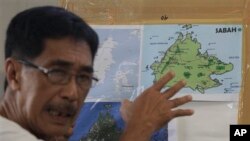 Abraham Idjirani, juru bicara Kesultanan Sulu, menunjukkan peta pulau Kalimantan saat memberika keterangan kepada para wartawan di wilayah Taguig, selatan Manila, Filipina (5/3). Malaysia telah mengerahkan pesawat tempur dan pasukannya untuk mengamankan wilayah Sabah yang tengah menjadi sengketa antara Malaysia-kelompok bersenjata Filipina.