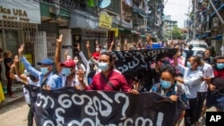 Anti-coup protesters hold a banner that reads "What are these? We are Yangon residents!" as they march during a demonstration in Yangon, Myanmar, April 27, 2021. 