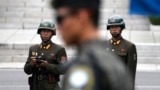 In this April 17, 2017, file photo, two North Korean soldiers look at the south side as a South Korean soldier, center, standing guard at the border village of Panmunjom which has separated the two Koreas since the Korean War, South Korea. South Korea's 