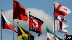 La bandera norcoreana (centro) ondea entre las banderas de otras naciones en la Villa Olímpica de los Juegos de Invierno 2018 en Gangneung, Corea del Sur, el 1 de febrero de 2018.