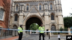 Police stand guard at the Abbey gateway of Forbury Gardens, a day after a multiple stabbing attack in the gardens in Reading, England, June 21, 2020. 