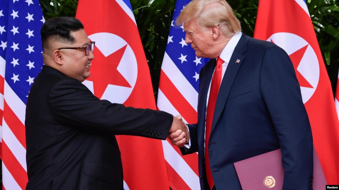 Presiden AS, Donald Trump, dan pemimpin Korea, Kim Jong Un, berjabat tangan dalam acara penandatanganan dokumen setelah pertemuan puncak antara kedua pemimpin di Capella Hotel, Pulau Sentosa, Singapura, 12 Juni 2018 (foto: Susan Walsh/Pool via Reuters)
