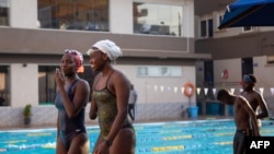 Ugandan Husnah Kukundakwe (2nd L), 16, interacts with a friend during a swimming training session at Elite swim and gym in Kampala on December 19, 2023, ahead of the 2024 Paris Paralympic games.