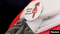 A badge reads "The power of labor aginst FGM" is seen on a volunteer during a conference on International Day of Zero Tolerance for Female Genital Mutilation in Cairo, Egypt, Feb. 6, 2018. 