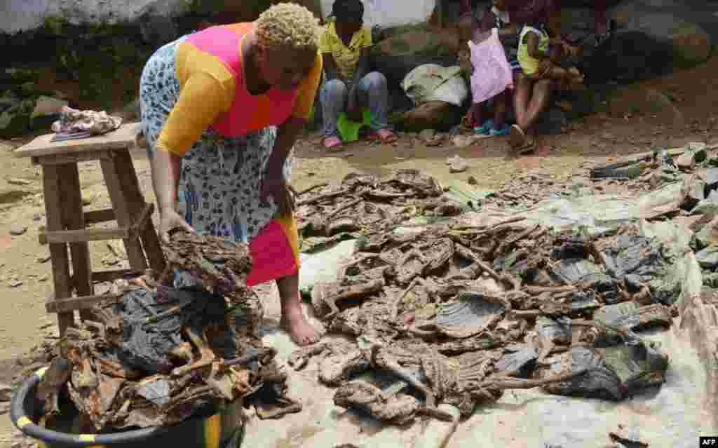 Alice Jallabah, chef d&#39;un groupe de vendeurs de viande de brousse, tient une viande de brousse séchée en main, le 7 octobre, 2014, à Monrovia, Liberia. La consommation de la viande de brousse est interdite au Liberia depuis que l&#39;épidémie du virus Ebola s&rsquo;est déclarée au Liberia. AFP PHOTO / ZOOM DOSSO 