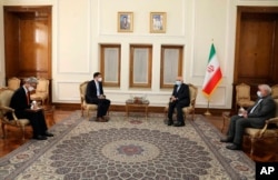 In this photo released by the Iranian Foreign Ministry, South Korean Vice Foreign Minister Choi Jong Kun, center left, speaks with Iranian Foreign Minister Mohammad Javad Zarif, center right, during their meeting in Tehran, Jan. 11, 2021.