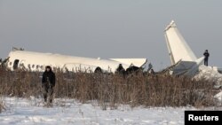 27일 카자흐스탄 알마티 인근에 여객기가 추락한 후 당국 대원들이 사고현장을 조사하고 있다. 