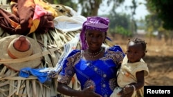 FILE - A woman carries her child in Nigeria's Kaduna State. 