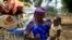 FILE - A woman carries her child in Nigeria's Kaduna State. 