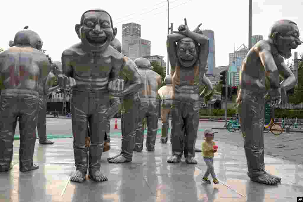 A child plays around sculptures outside a residential area in Beijing, China, June 5, 2021.