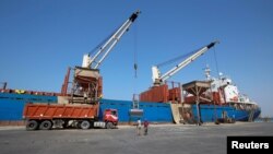 FILE - Workers unload aid shipment of wheats from St. George ship, at the Red Sea port of Hodeidah, Yemen Nov. 30, 2017. 