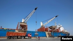 FILE - Workers unload aid shipment of wheats from St. George ship, at the Red Sea port of Hodeidah, Yemen Nov. 30, 2017. 