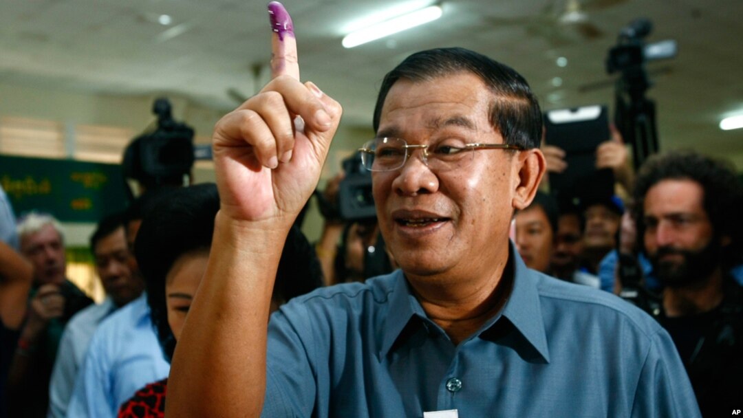 PM Kamboja Hun Sen menunjukkan jarinya setelah memberikan suara di TPS kota Takhmau, selatan ibukota Phnom Penh (28/7). 